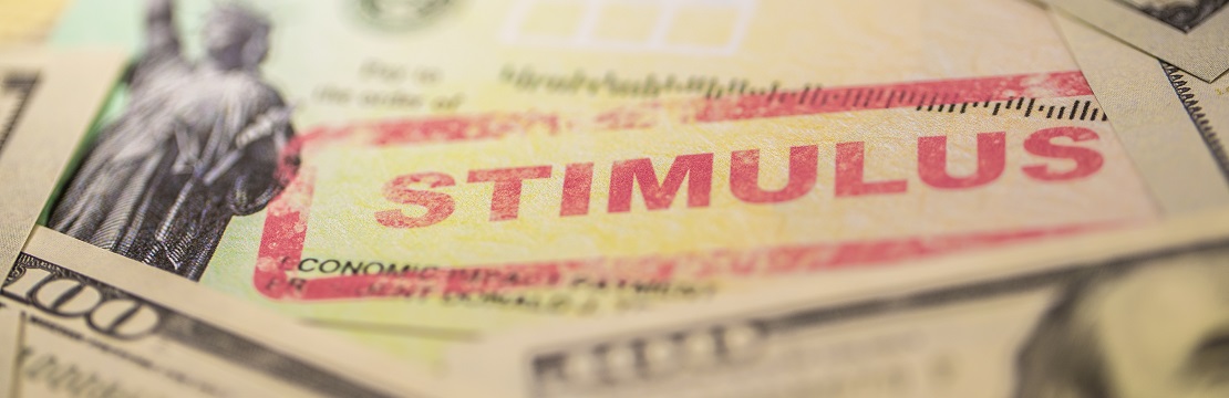 A check stamped with "stimulus" among dollar bills